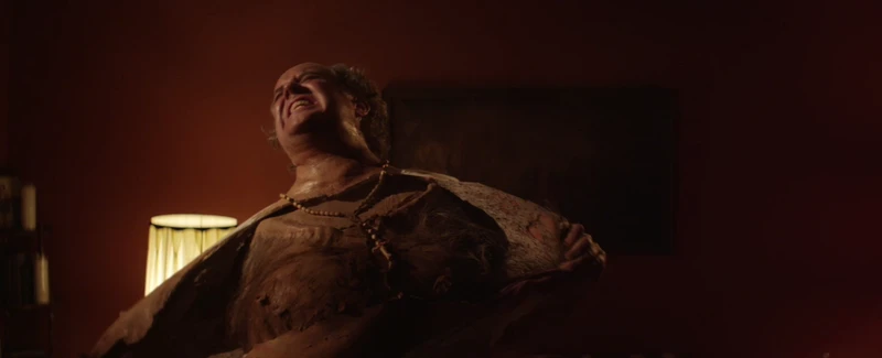 Yes, he is wearing a latex mask of his own face. Yes, he is wearing a latex mask of his own face.